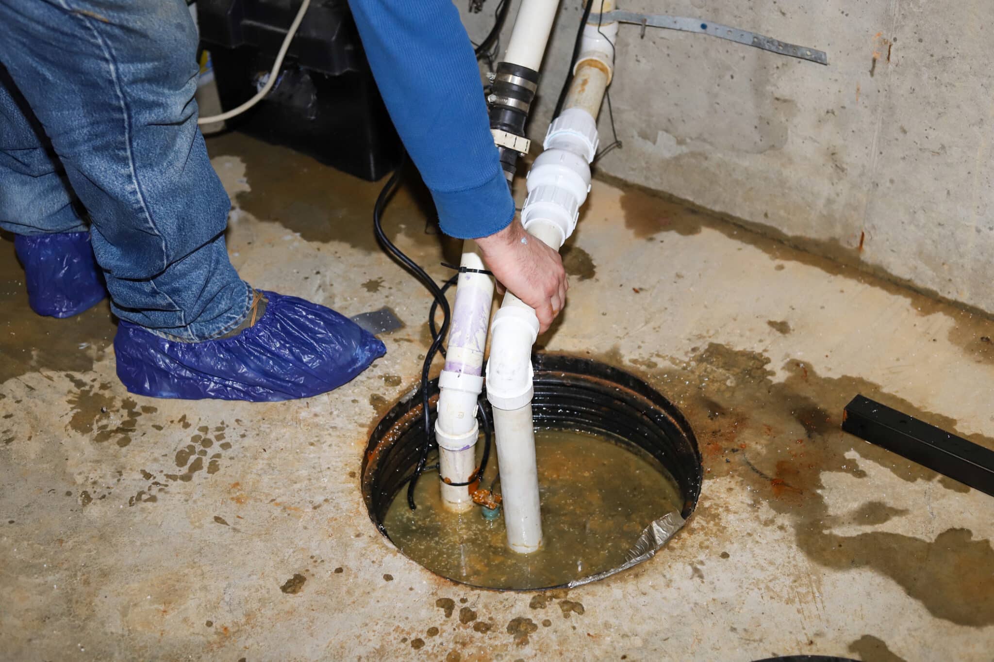 Spring plumbing checkup: ensuring your sump pump is ready 1 Sump pump in a flooded basement in a residential home.
