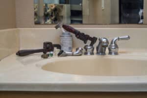 A photo of a broken faucet with parts and tools, Leaky faucet repair.