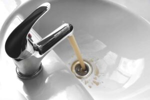 Discolored water from a faucet as one of the top signs you need water heater servicing now.