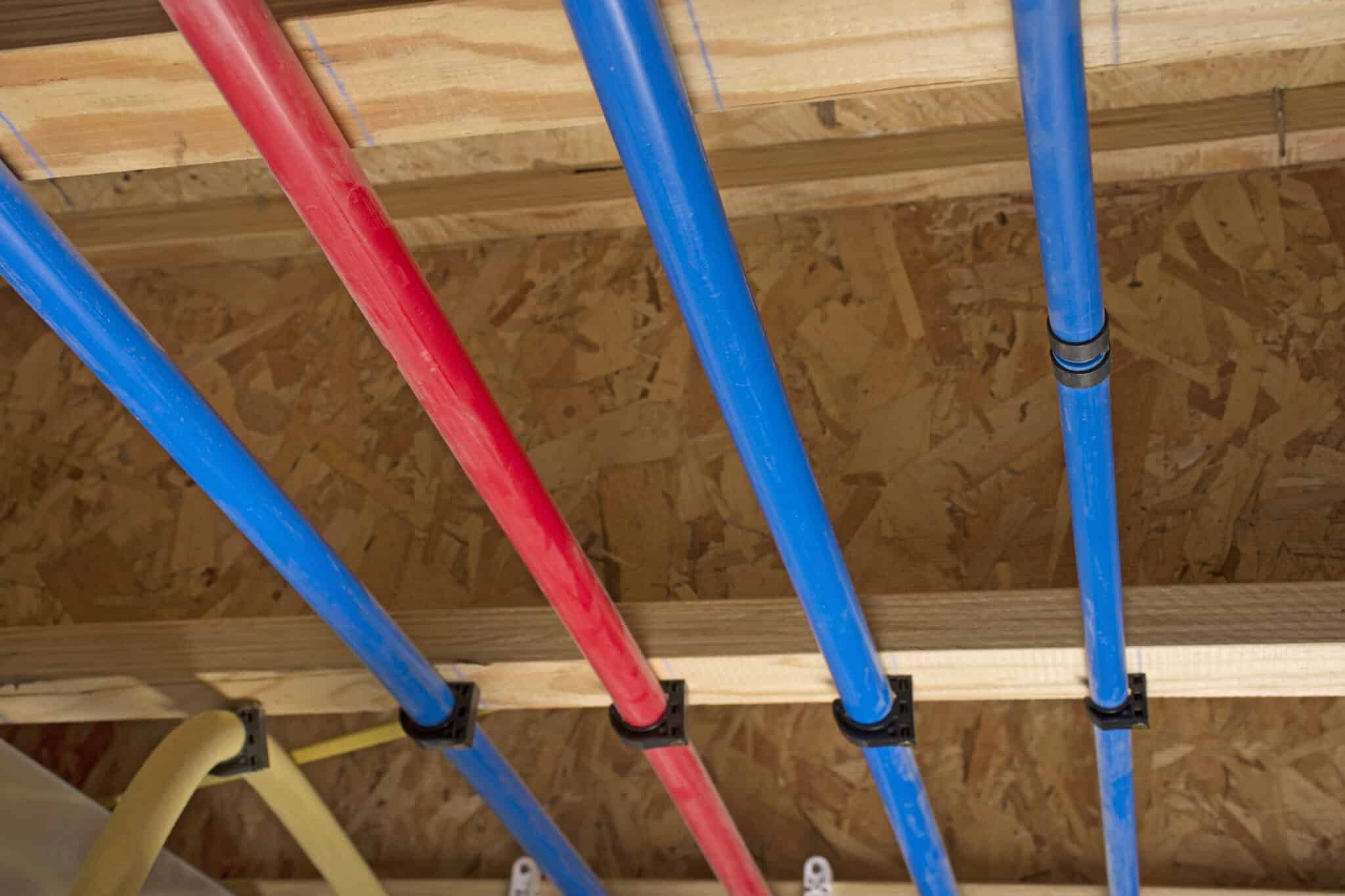 Pex pipes attached to the basement ceiling of a home, pex manifold setup.