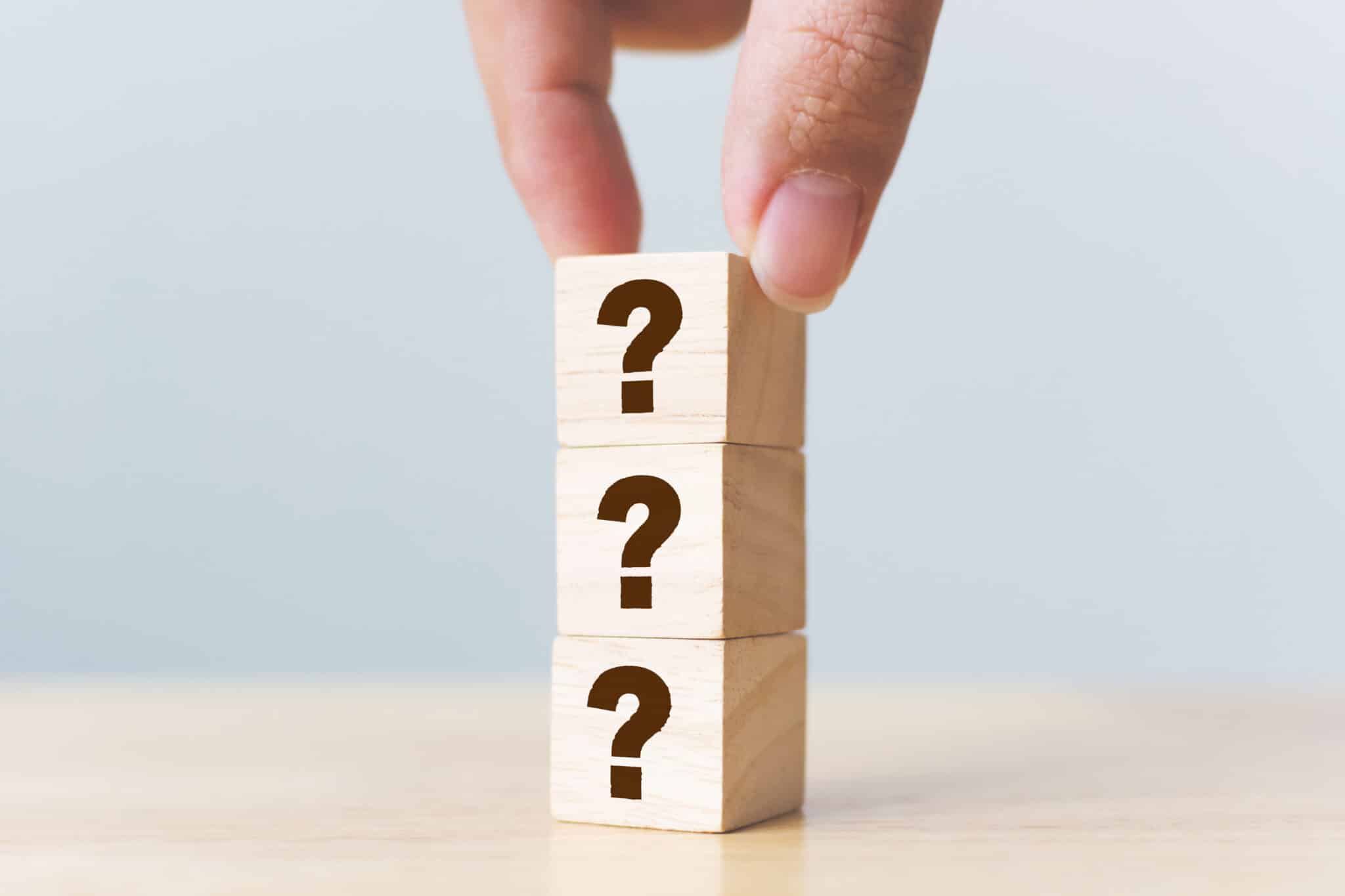 Wooden cube block shape with sign question mark symbol on wood table, recirculation pump timer.