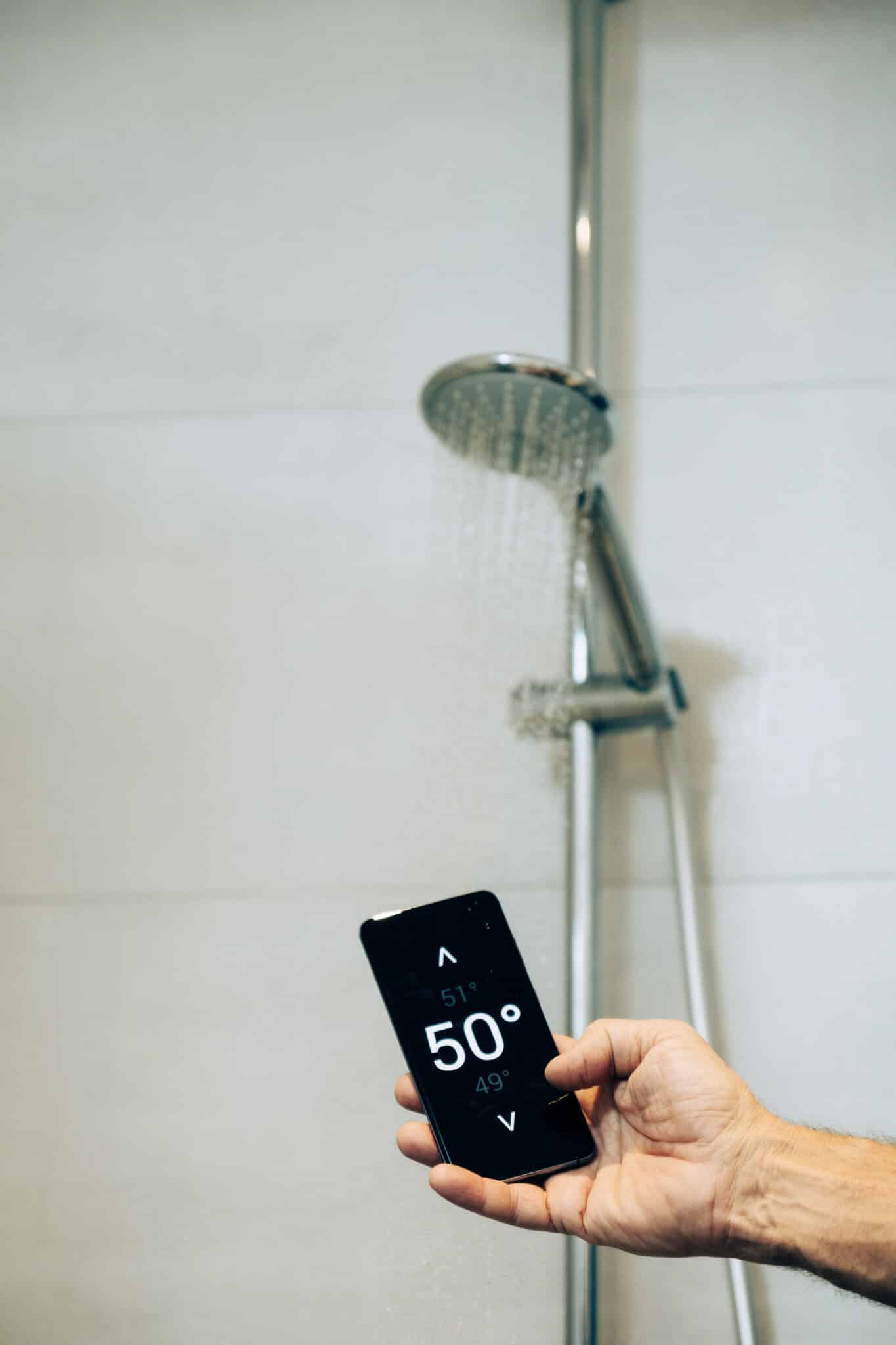 Smart shower systems benefits for modern homes 1 Smart home concept man controlling warm water temperature, smart shower systems.