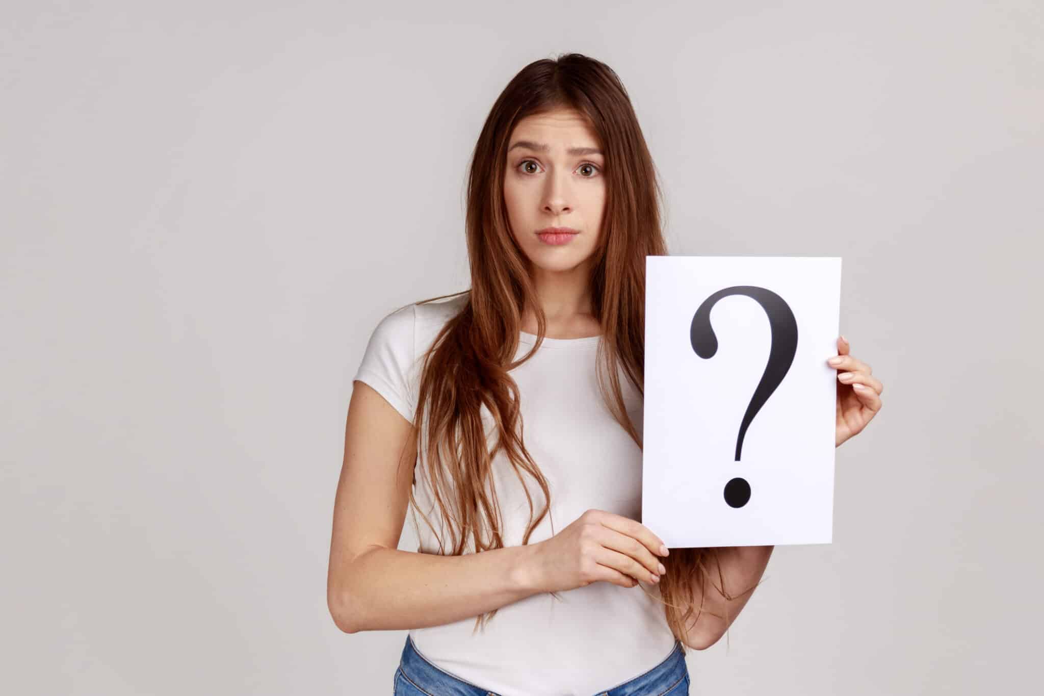 Woman holding paper with question mark, why, shower drain upgrade.
